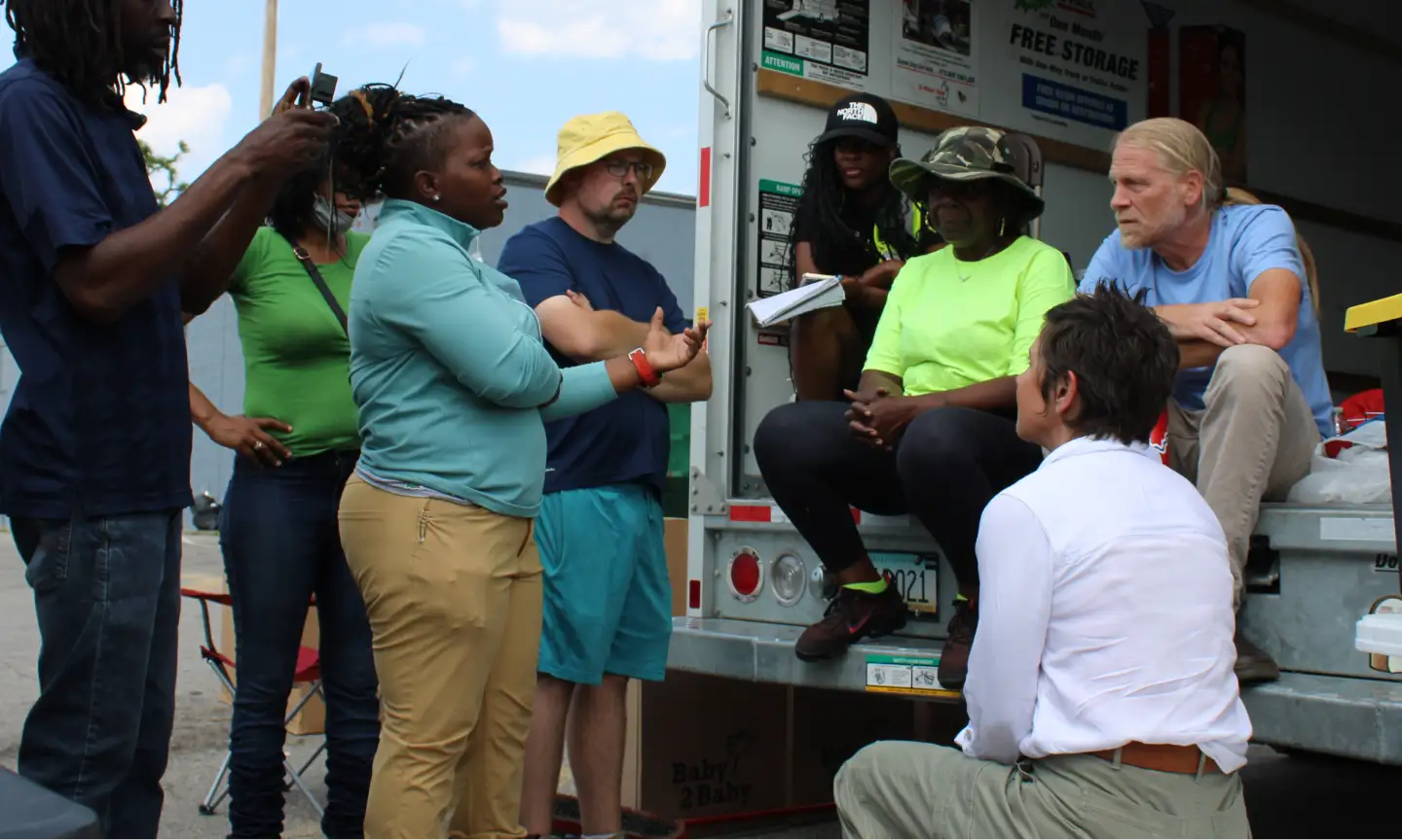 Volunteers and city workers assisting residents with debris removal and home stabilization in St. Louis