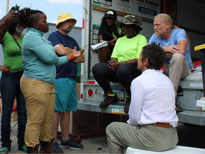 Volunteers and city workers assisting residents with debris removal and home stabilization in St. Louis